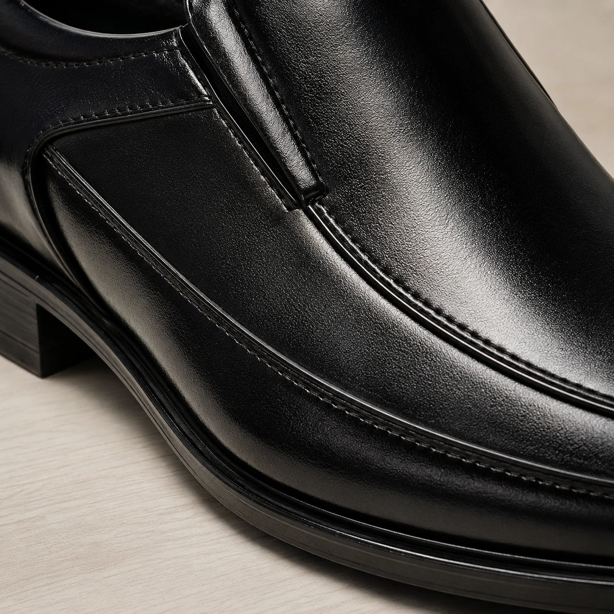 Detalle de zapato formal negro sin cordones para hombre